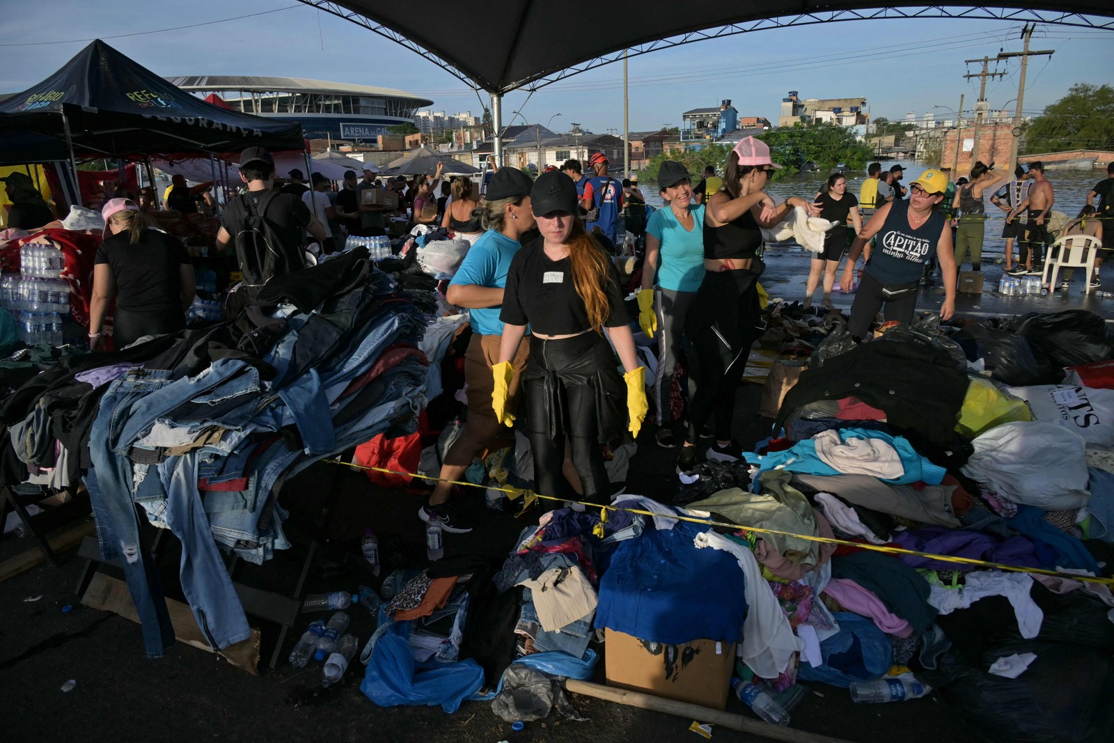 Um voluntário organiza roupas doadas para serem distribuídas entre os evacuados das enchentes, no bairro Humaitá, em Porto Alegre, Rio Grande do Sul — Foto: NELSON ALMEIDA / AFP