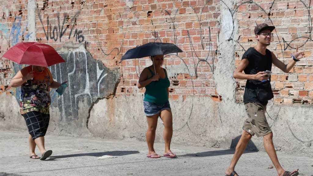 Três pessoas andando em dia ensolarado