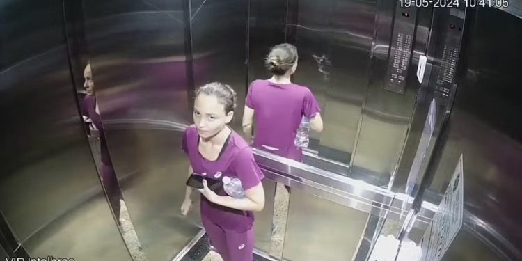 Júlia Andrade com roupas de academia no interior do elevador