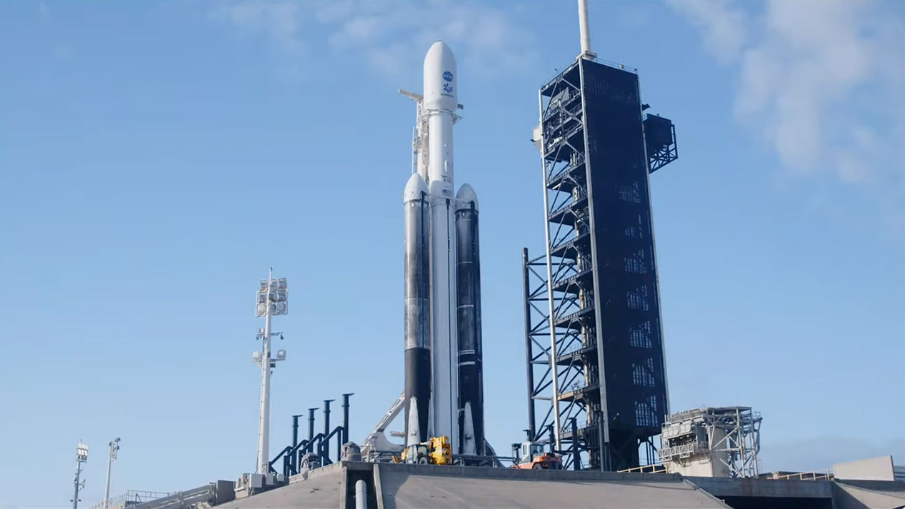 A triple booster SpaceX Falcon Heavy rocket carrying NASA's Europa Clipper spacecraft on the launch pad.